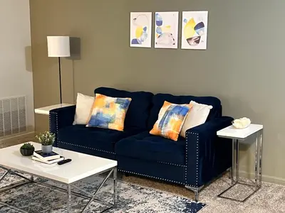 a blue couch in a living room with a table at FREE Parking Minutes from Center City in Hilltop