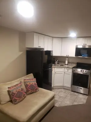 a living room with a couch and a kitchen at The Airport Lodge in Collingdale