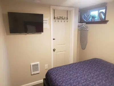 a bedroom with a bed and a flat screen tv at The Airport Lodge in Collingdale