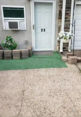 a front door of a house with a green lawn at The Airport Lodge in Collingdale