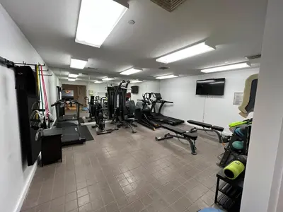 a gym with several treadmills and machines in a room at National at 888 Sixth Avenue - Furnished Apartments in New York
