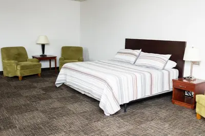 a bedroom with a bed and two chairs at Mountain View Lodge in Clifford