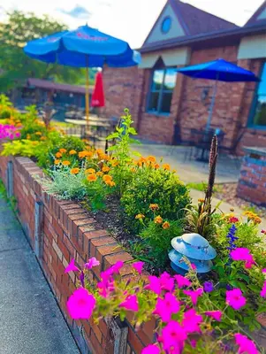 a brick retaining wall with flowers and an umbrella at Mountain View Lodge in Clifford