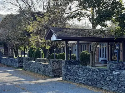 a building with a stone wall next to a street at Mountain View Lodge in Clifford