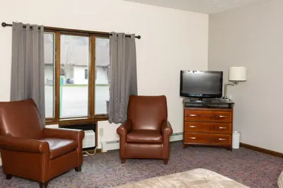 a hotel room with two chairs and a television at Mountain View Lodge in Clifford
