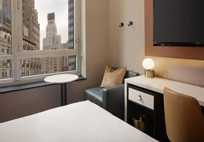 a room with a bed and a window and a chair at Hotel Indigo NYC Downtown - Wall Street by IHG in New York