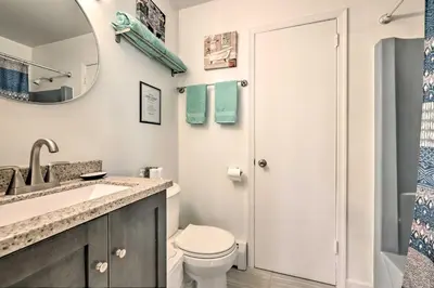 a bathroom with a toilet and a sink and a mirror at Deck and Backyard Tobyhanna Family Home in Tobyhanna