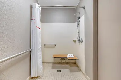 a shower with a bench in a bathroom at Red Roof Inn Parsippany in Parsippany