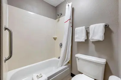 a bathroom with a white toilet and a bath tub at Red Roof Inn Parsippany in Parsippany