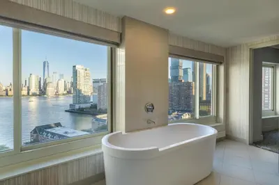 a bathroom with a tub and a large window at The Westin Jersey City Newport in Jersey City