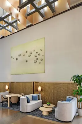 a lobby with couches and tables and a painting on the wall at The Westin Jersey City Newport in Jersey City