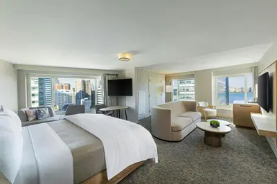 a bedroom with a large bed and a living room at The Westin Jersey City Newport in Jersey City