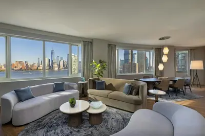 a living room with couches and a large window at The Westin Jersey City Newport in Jersey City