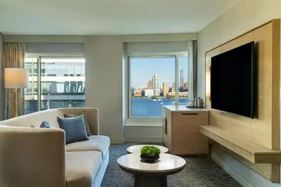 a living room with a couch and a tv at The Westin Jersey City Newport in Jersey City