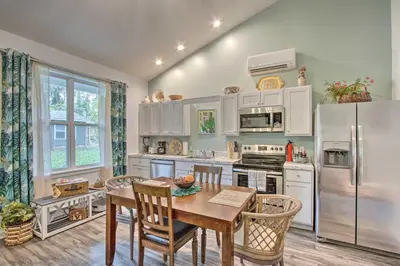 a kitchen with a table and a refrigerator at Hike and Ski! Blue Heron Brodheadsville Cottage in Brodheadsville