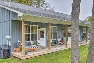 a green house with a porch and a patio at Hike and Ski! Blue Heron Brodheadsville Cottage in Brodheadsville