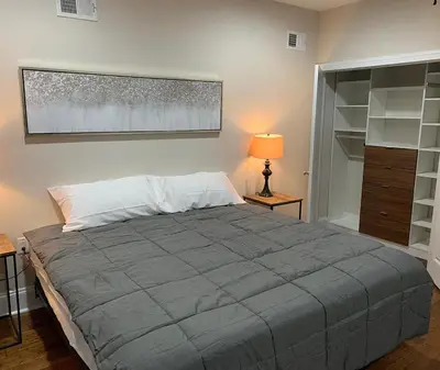 a bedroom with a large bed and a lamp and shelves at Center City Roofdeck Hot Tub w Garage in Philadelphia