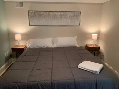 a large bed with two lamps on two tables at Center City Roofdeck Hot Tub w Garage in Philadelphia