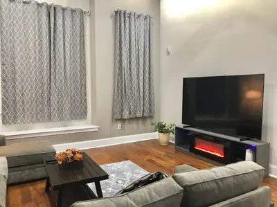 a living room with a couch and a flat screen tv at Center City Roofdeck Hot Tub w Garage in Philadelphia