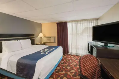 a hotel room with a bed and a flat screen tv at Days Inn By Wyndham Carlisle North in Carlisle
