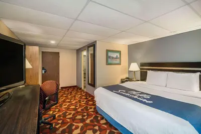 a hotel room with a bed and a flat screen tv at Days Inn By Wyndham Carlisle North in Carlisle