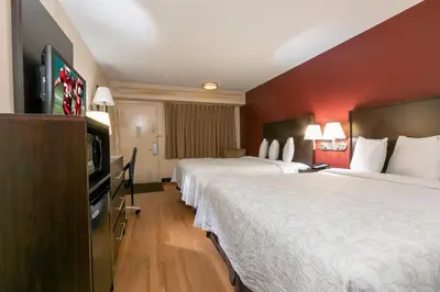 a hotel room with two beds and a flat screen tv at Red Roof Inn PLUS+ Wilmington - Newark in Christiana
