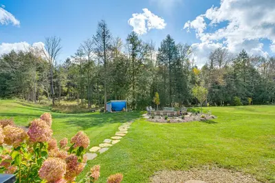 a garden with a picnic table and a blue shed at Spacious and Secluded Forksville Home Fire Pit in Forksville