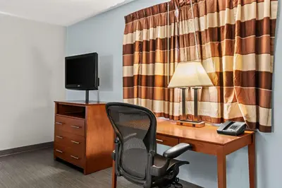 a room with a desk with a chair and a television at Americas Best Value Inn Carlisle in Carlisle