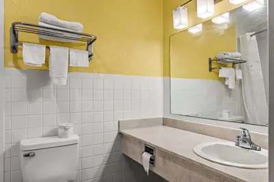 a bathroom with a sink and a toilet and a mirror at Americas Best Value Inn Carlisle in Carlisle