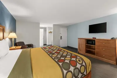 a hotel room with a bed and a flat screen tv at Americas Best Value Inn Carlisle in Carlisle