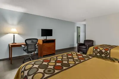 a hotel room with two beds and a desk and a chair at Americas Best Value Inn Carlisle in Carlisle