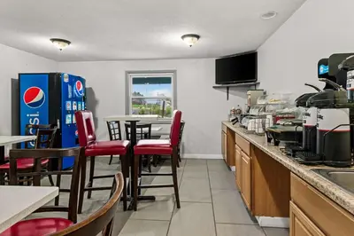 a kitchen with a counter and a table with chairs at Americas Best Value Inn Carlisle in Carlisle