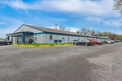 a building with cars parked in a parking lot at Americas Best Value Inn Carlisle in Carlisle