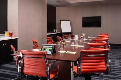 a conference room with a long table and red chairs at Courtyard by Marriott New York Manhattan/Central Park in New York