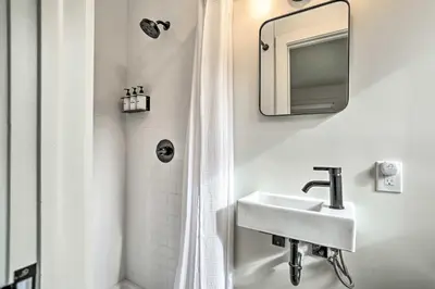 a white bathroom with a sink and a shower at Modern Hideaway with Deck and State Forest Access in Livingston Manor
