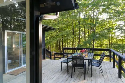 a patio with a table and chairs on a deck at Modern Hideaway with Deck and State Forest Access in Livingston Manor