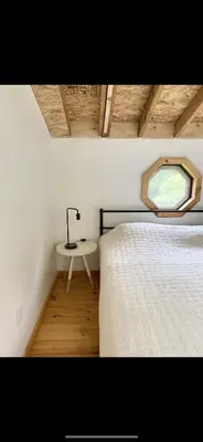 a bedroom with a bed and a table with a lamp at The Cabin at Parkhill in Downsville