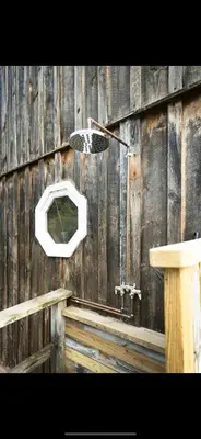a wooden wall with a mirror and a sink at The Cabin at Parkhill in Downsville