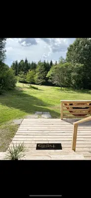 a wooden bench sitting on top of a wooden deck at The Cabin at Parkhill in Downsville