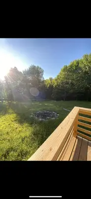 a wooden bench sitting in a field of grass at The Cabin at Parkhill in Downsville