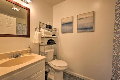 a bathroom with a sink and a toilet and a mirror at Resort Perks and Lake Access Poconos Retreat in Pocono Summit