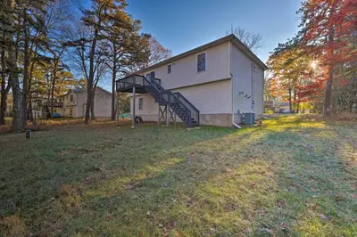 a house with a staircase next to a yard at Resort Perks and Lake Access Poconos Retreat in Pocono Summit