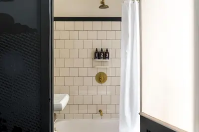 a bathroom with a tub and a sink and a toilet at Ace Hotel New York in New York