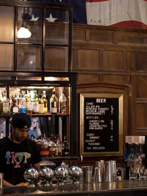 a man standing behind a bar in a restaurant at Ace Hotel New York in New York