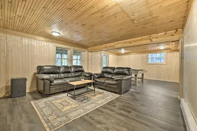 a living room with leather couches and a table at Game Room, Fire Pit and Deck Spacious Poconos Home! in Lake Harmony