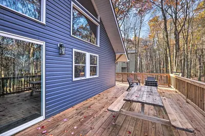 a wooden deck with a bench on the side of a house at Game Room, Fire Pit and Deck Spacious Poconos Home! in Lake Harmony