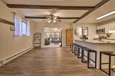a kitchen with a ceiling fan and bar stools at Cozy Poconos Ranch Home with Pool Access, Near Lake! in Gouldsboro