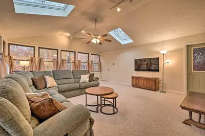 a living room with a couch and a table at Cozy Poconos Ranch Home with Pool Access, Near Lake! in Gouldsboro