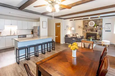 a kitchen and living room with a wooden table and chairs at Cozy Poconos Ranch Home with Pool Access, Near Lake! in Gouldsboro