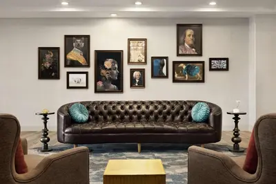a living room with a leather couch and pictures on the wall at Homewood Suites By Hilton Carlisle in Carlisle